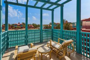 a balcony with chairs and tables and a view of a park at Sheraton Miramar Resort El Gouna in Hurghada