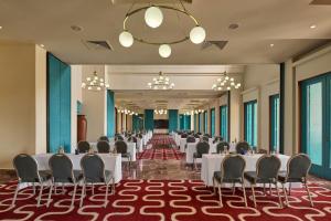 a banquet hall with white tables and chairs and a chandelier at Sheraton Miramar Resort El Gouna in Hurghada +37 photos