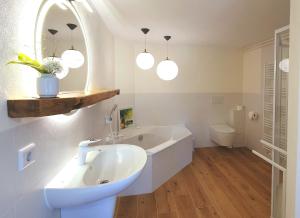 a white bathroom with a tub and a sink at Ferienhaus Hummel-Nest in Laußnitz