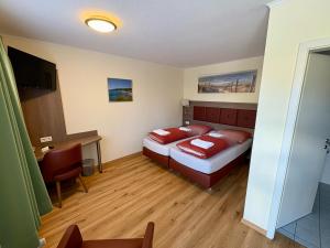 a bedroom with a bed and a desk and a television at Ellen Hotel in Flensburg +26 photos