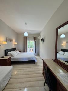 a hotel room with two beds and a mirror at Olive Garden Studios & Apartments in Acharavi