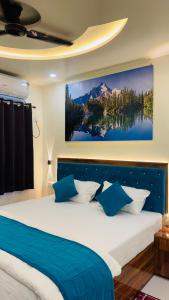 a bedroom with a large bed with blue pillows at Hotel RJ in Patna