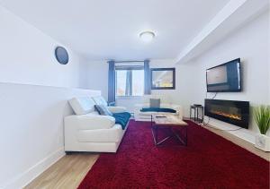 Una sala de estar con un sofá blanco y un televisor. en Élégant et cosy - 2 chambres bien équipé et parking gratuit, en Montreal