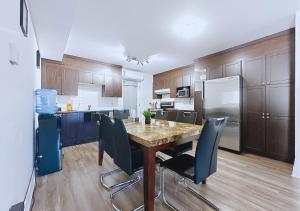 Una cocina con una mesa con sillas y un refrigerador. en Élégant et cosy - 2 chambres bien équipé et parking gratuit, en Montreal