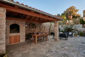 an outdoor patio with a wooden pergola at Cavtat Micika Apartment in Zvekovica