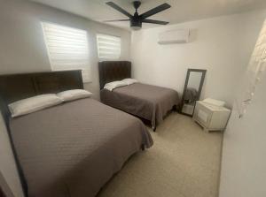a bedroom with two beds and a ceiling fan at Casa Ramos in Aguadilla +14 photos