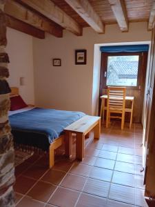 sypialnia z łóżkiem, stołem i oknem w obiekcie Hotel Rural Las Encinas w mieście Santa María de Redondo