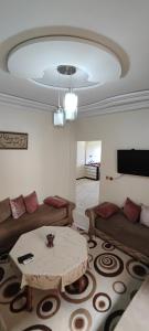 un soggiorno con un divano e un tavolo di Appartement meublé à louer a Meknès