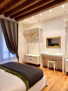 a bedroom with a bed and a desk and a mirror at Ca' Emma in Venice
