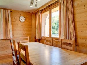 a dining room with a wooden table and a clock at Chalet rénové 3 chambres, proche centre Courchevel - FR-1-514-25 in le Praz +5 photos