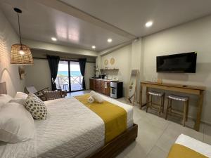 a bedroom with a bed and a kitchen and a television at Litos Hotel in La Libertad