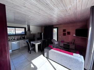 a kitchen and living room with a couch and a table at Villa Les Vignes in Salavas