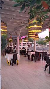 a restaurant with tables and chairs and chandeliers at Litos Hotel in La Libertad