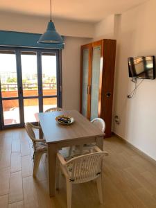 a dining room with a wooden table and chairs at Orizzonte Blu Holiday Home in Scalea +8 photos