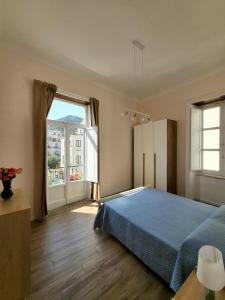 Un dormitorio con una cama azul y una gran ventana. en Casa Bonita Guest House, en Salerno
