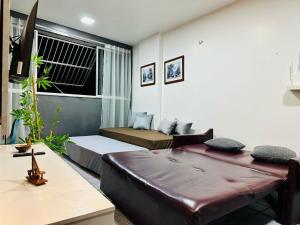 een woonkamer met twee bedden en een bank bij Vista mar, piscina, na praia do futuro, com Ar condicionado e Wi-Fi in Fortaleza +32 foto's