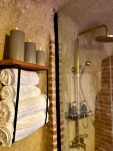 a bathroom with a shower and a shelf with towels at Loft La Cueva del Niño in Vejer de la Frontera +10 photos