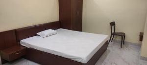 Un dormitorio con una cama y una silla dentro. en Hotel DEEPAK PALACE, en Gaya