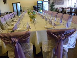 a long table with chairs and plates and napkins at Motel DHS - Chinese Restaurant in Deva