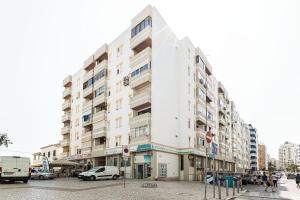 een groot wit gebouw aan een stadsstraat bij Vieira Casino in Armação de Pêra