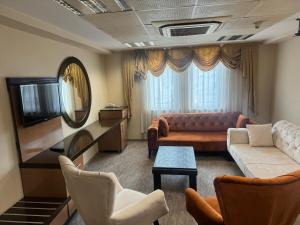 a living room with a couch and a tv at körfez otel in Edremit