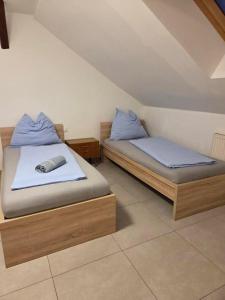 two beds with blue pillows in a room at Gästezimmer Schwanenstadt in Schwanenstadt