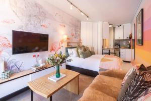 a bedroom with a bed and a couch and a table at Elegant Studio by the Sea in Cape Town