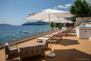 Una fila de bancos con sombrillas y el agua. en TRL Lefkada, en Nydri 29 fotos más