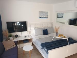 a bedroom with a bed and a desk and a tv at App Hedonist in Novigrad Istria +5 photos