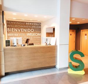 a reception desk in a building with a s sign at Hotel Sercotel Portales in Logroño
