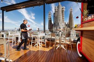 een man op een dek met uitzicht op de stad bij Sercotel Hotel Rosellon in Barcelona +37 foto's