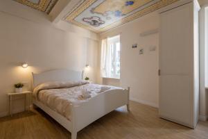 a bedroom with a white bed with a ceiling at Locus Amoenus in Riomaggiore