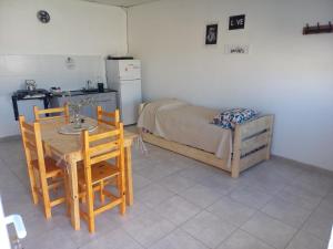 una habitación con una mesa y sillas y una cama en Departamentos TUNQUELEN, en Río Colorado