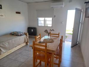 Habitación con mesa, cama, mesa y sillas. en Departamentos TUNQUELEN, en Río Colorado