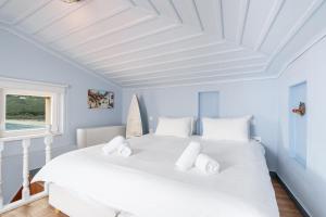 a white bed in a room with a white ceiling at Castel Abaso Boutique Apartments by Explore Andros in Andros