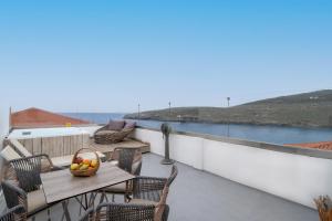 a balcony with a table with a bowl of fruit on it at Castel Abaso Boutique Apartments by Explore Andros in Andros