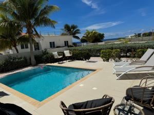 a swimming pool with chairs next to a house at Beautiful Villa on the Sea in Lagun