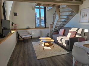 a living room with a couch and a staircase at Nid calme et cosy - Hypercentre avec superbe vue! in Besançon
