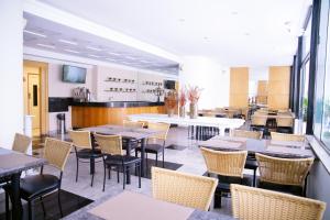a restaurant with tables and chairs and a counter at Hotel BH Palace in Belo Horizonte