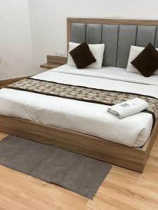 ニューデリーにあるHotel The Metropolitan Plaza Near IGI Airport Delhiの大型ベッド(金属製のヘッドボード、白いシーツ付) +35枚の写真