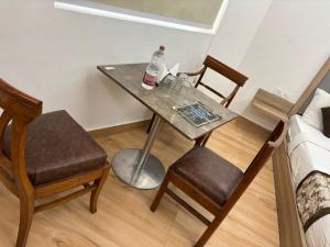 ニューデリーにあるHotel The Metropolitan Plaza Near IGI Airport Delhiのテーブル(アルコール1本付)、椅子