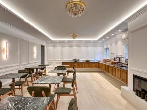 a restaurant with tables and chairs and a kitchen at Armata Boutique Hotel in Spetses