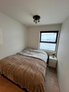 Un dormitorio pequeño con una cama y una ventana. en Studio Apartment in Akureyri, Iceland, en Akureyri