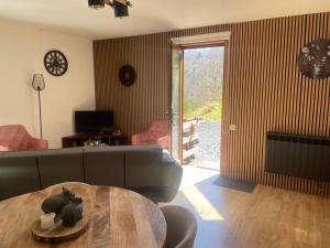 un salon avec un canapé et une table dans l'établissement Le cottage de Christine, à Vresse-sur-Semois