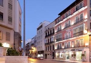 eine Häuserreihe in einer Stadtstraße bei Nacht in der Unterkunft Sercotel Tribuna Málaga in Málaga