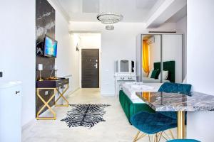 a living room with a table and blue chairs at Mamaia Nord Resort Premium in Mamaia Sat/Năvodari