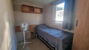 a small bedroom with a bed and a window at Charmant bungalow à Piriac-sur-Mer avec piscine partagée in Piriac-sur-Mer +14 photos