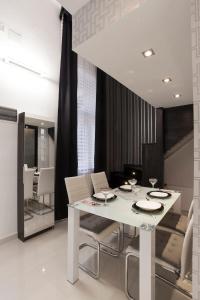 Un comedor con una mesa y sillas blancas. en Silver Apartment, en Budapest 19 fotos más