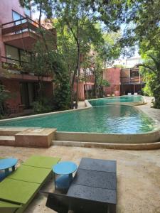 a swimming pool with tables and chairs in front of a building at Caribbean soul in Tulum