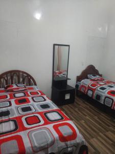Un dormitorio con dos camas y un espejo. en Canelita house, en Puerto Villamil